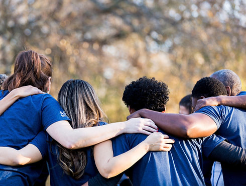 Sports team with men and women of different ethnicities holding shoulders